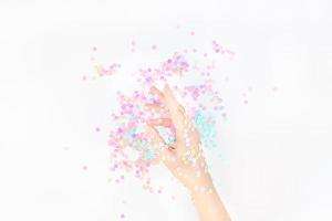 Perlpastellkonfetti funkelt mit Frauenhand foto