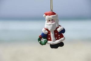 Weihnachtsmann-Puppe mit verschwommenem Strandhintergrund foto