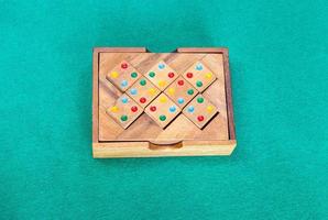 Holzkiste mit Puzzle am grünen Tisch foto