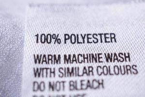 Kleidungsetikett aus Polyestergewebe mit Waschanleitung foto