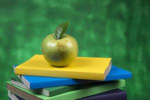 Apfelfrucht auf einem Bücherstapel, auf dem Rücken von Schulklassen. foto