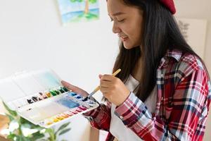 junges mädchen malt zu hause auf papier, holzrahmen, hobby und kunststudium zu hause. foto