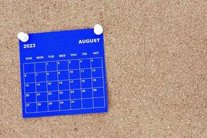 august 2023 blauer kalender mit pin auf kork-bulletin-plakatwand. foto