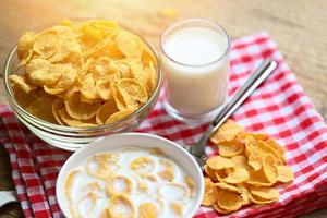 cornflakes schüssel frühstück und snack für ein gesundes lebensmittelkonzept, morgendliches frühstück frisches vollkornmüsli, cornflakes mit milch auf tischhintergrund foto