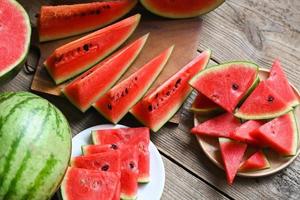 Wassermelonenscheibe auf Teller und Holzhintergrund, Nahaufnahme süße Wassermelonenscheiben Stücke frische Wassermelone tropische Sommerfrucht foto