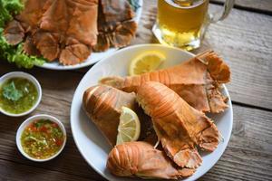 frischer Pantoffelhummer Flathead gekocht Kochen mit Petersilie Rosmarin im Restaurant, Flathead Hummergarnelen serviert auf weißem Teller Meeresfrüchtesoße und Becher Bierglas, Rock Lobster Moreton Bay Bug foto