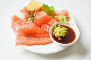 wasabi sauce rohes lachsfilet auf weißem teller - frischer lachsfisch zum kochen von salat meeresfrüchten japanisches essen foto