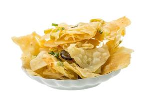 Nachos auf dem Teller und weißem Hintergrund foto