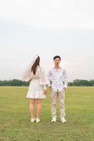 glückliches junges asiatisches paar in braut- und bräutigamkleidung foto
