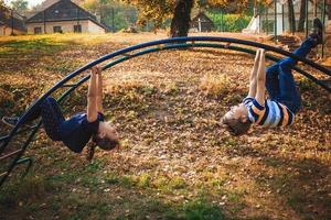 Verspielter Junge und Mädchen, die sich auf dem Spielplatz amüsieren. foto