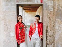 glückliches junges asiatisches paar in chinesischen traditionellen kleidern foto
