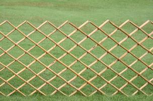 Bambuszaun auf Gartenhintergrund des grünen Grases foto