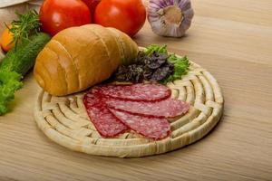 Salami auf Holzbrett und Holzhintergrund foto