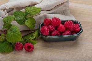 frische Himbeere in einer Schüssel auf hölzernem Hintergrund foto