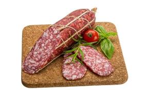 Salami auf Holzbrett und weißem Hintergrund foto