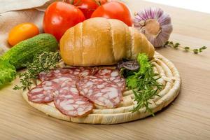 Salami auf Holzbrett und Holzhintergrund foto