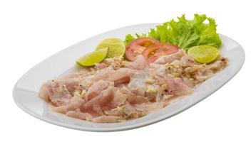 Schwertfisch-Carpaccio auf dem Teller und weißem Hintergrund foto