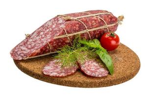 Salami auf Holzbrett und weißem Hintergrund foto