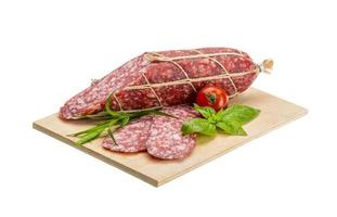 Salami auf Holzbrett und weißem Hintergrund foto