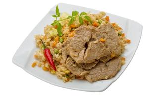 gebratener Reis mit Schweinefleisch auf dem Teller und weißem Hintergrund foto
