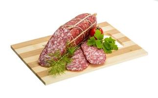 Salami auf Holzbrett und weißem Hintergrund foto