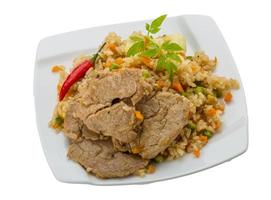 gebratener Reis mit Schweinefleisch auf dem Teller und weißem Hintergrund foto