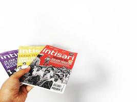 west java, indonesien im juli 2022. eine hand hält zeitschriften foto