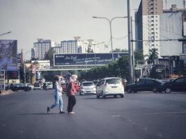 west java, indonesien im juli 2022. zwei muslimische frauen mit kopftüchern überqueren die straße nicht am richtigen ort. foto