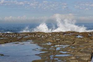 Wellen, die über Felsen krachen foto