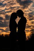 Silhouette eines romantischen Paares in Liebe, Mann und Frau im Sonnenunterganghimmel. Romantik der Beziehungen zwischen Liebespaaren im Garten foto