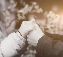 Zwei Liebhaber, die Hände in Handschuhen halten foto