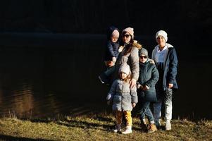 Mutter mit vier Kindern im Pfund im Vorfrühlingspark. foto