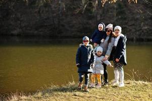 Mutter mit vier Kindern im Pfund im Vorfrühlingspark. foto