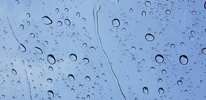 Perspektive der Wassertropfen durch die Fensterglasoberfläche gegen den blauen Himmel, gut für Multimedia-Inhalte foto