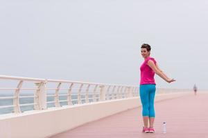 Frau, die sich auf der Promenade ausdehnt und aufwärmt foto