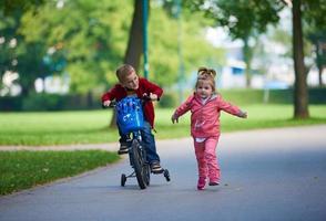 Junge und Mädchen mit Fahrrad foto