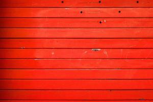 Gestreifte metallstrukturierte Wand in Rot lackiert, Hintergrund, abstrakte horizontale Linien, schmutziges stahlfarbenes Fensterladen-Garagentor, Grunge-Textur und Muster. foto