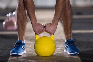 Männerübung mit Fitness-Kettlebell foto