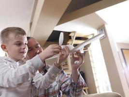 Vater und Sohn bauen Flugzeugspielzeug zusammen foto