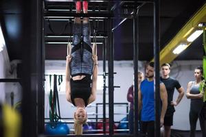 frau, die mit persönlichem trainer an gymnastikringen trainiert foto