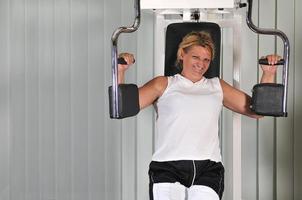 Reife Frau trainiert in Fitness foto