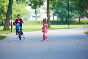 Junge und Mädchen mit Fahrrad foto