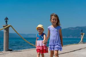 kleine Schwestern, die an der Strandküste spazieren gehen foto