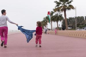 Mutter und süßes kleines Mädchen auf der Promenade am Meer foto