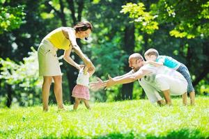 glückliches junges Paar mit ihren Kindern haben Spaß im Park foto