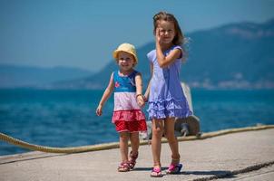 kleine Schwestern, die an der Strandküste spazieren gehen foto