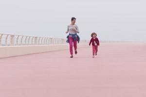 Mutter und süßes kleines Mädchen auf der Promenade am Meer foto