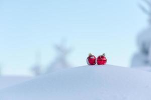 rote weihnachtskugeln im frischen schnee foto