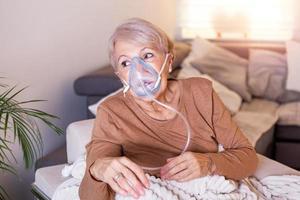 kranke ältere frau, die einatmen macht, medizin ist die beste medizin. Kranke Seniorin, die eine Sauerstoffmaske trägt und sich einer Behandlung unterzieht. ältere Frau mit einem Inhalator foto