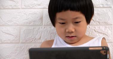 süßer kleiner junge, der zu hause einen tablet-computer verwendet. foto